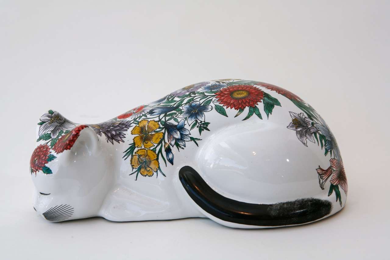 A whimsical sleeping ceramic cat by Piero Fornasetti decorated with a colorful transfer print of various flowers. Features the artist's mark and number 12 on the back (see Image 6).