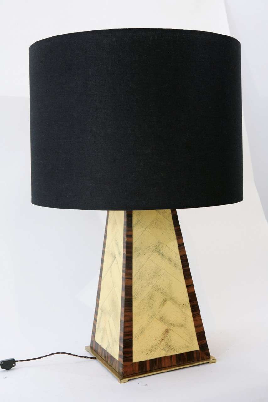 A handsome table lamp by Karl Springer with a lacquered faux bone herringbone pattern edged in faux zebrawood and set on a brass footed base measuring 10