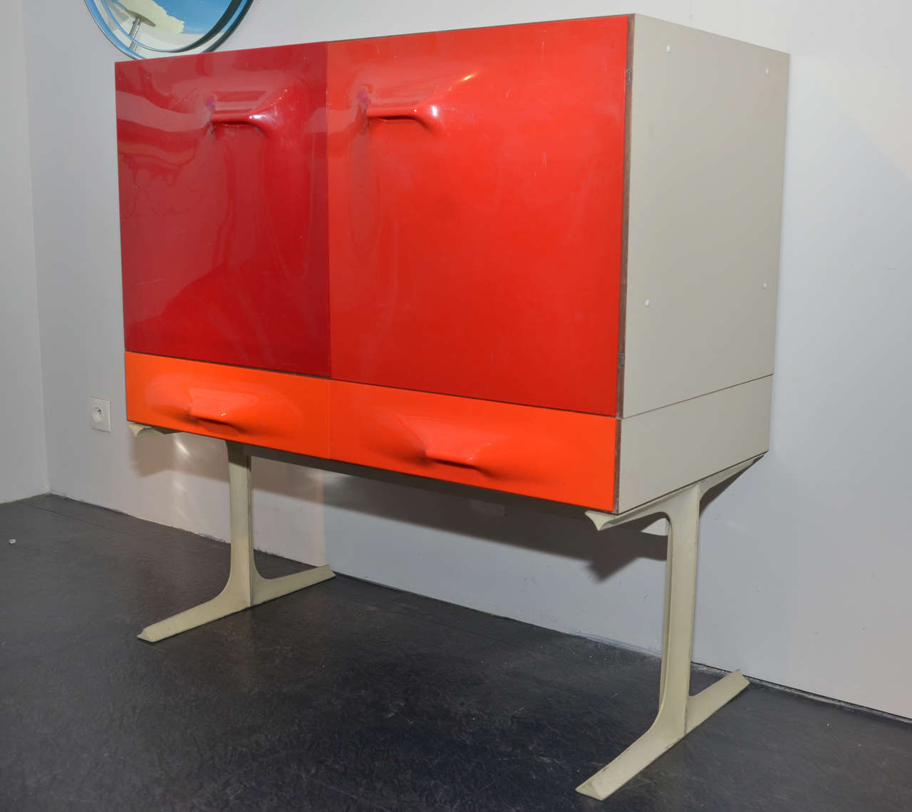 Small 1968 cabinet by  Raymond Loewy Edited by BF 2000 (label in one drawer) in white plywood with doors and drawers in orange and red thermo-shaped ABS ; cast iron legs; four interior drawers in orange and yellow lacquered wood.