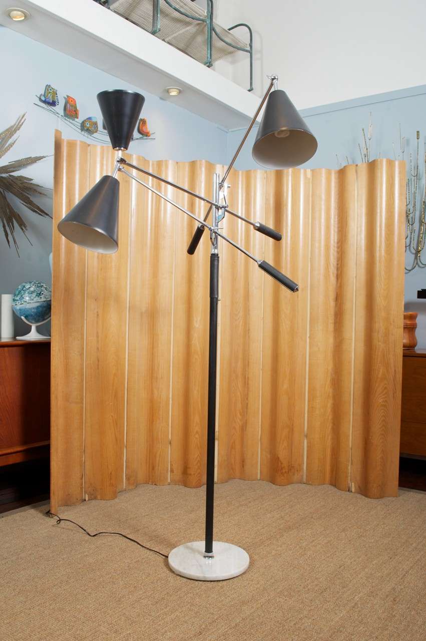 Incredible Arteluce Triennale floor lamp with three adjustable arms. All three shades are black with chrome arms and black leather handles. Circular marble base. Illuminates with on cord foot switch or turn switch on neck. Can use one, two or all