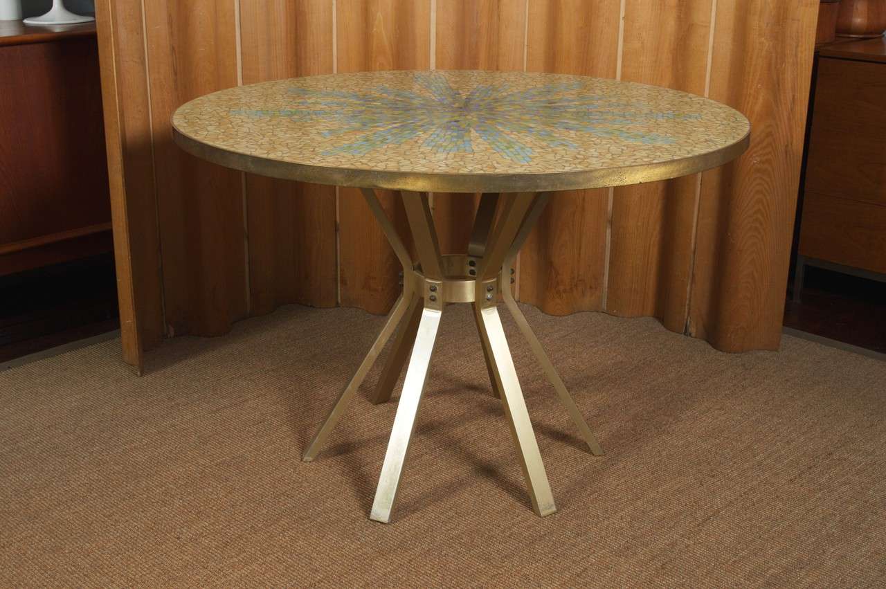 Stunning mosaic inlaid glass top table in a brushed brass frame and base. Indoor or out it will add texture and color to your modern living abode.