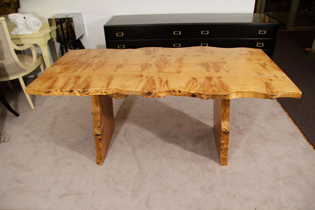 This dining table is made from Curly Maple wood. It is in the style of Nakashima and is considered a 