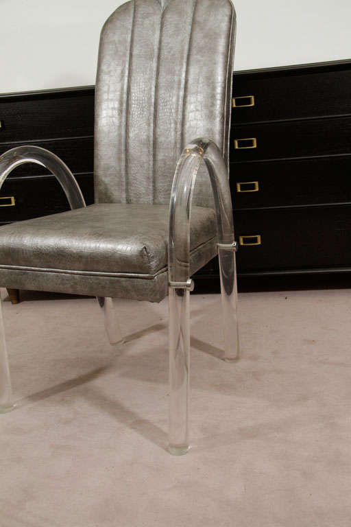 A set of four dining chairs in the style of Charles Hollis Jones, produced circa 1970s, with frames and curved waterfall legs in lucite, upholstered in gunmetal gray, faux alligator leatherette. Very good condition, consistent with age and use.

9685