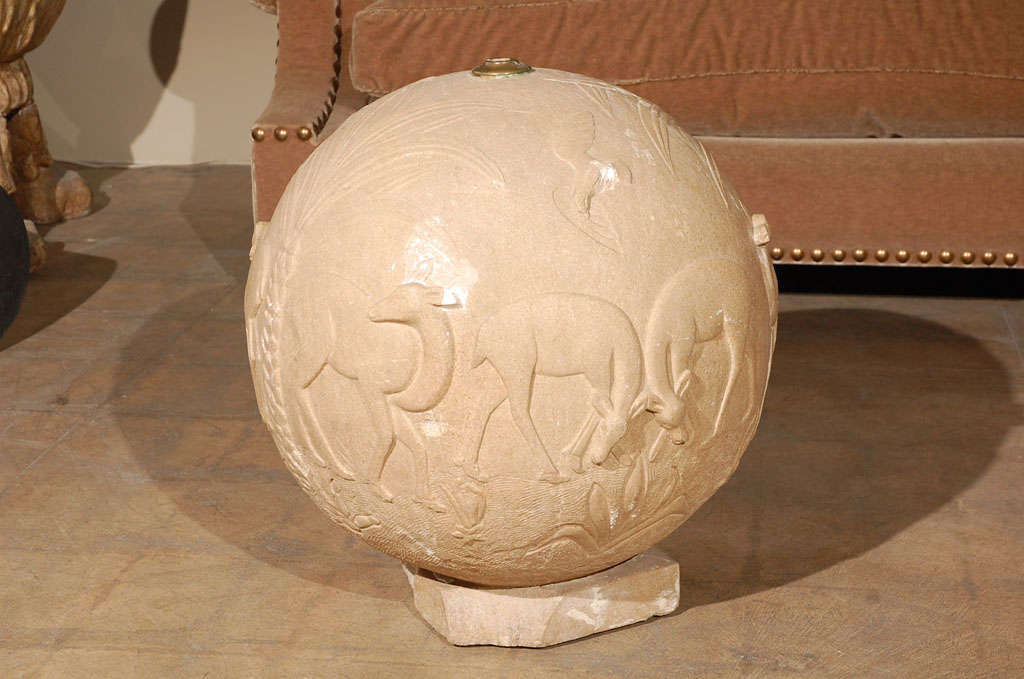 Sphère en pierre sculptée représentant un cerf en train de brouter