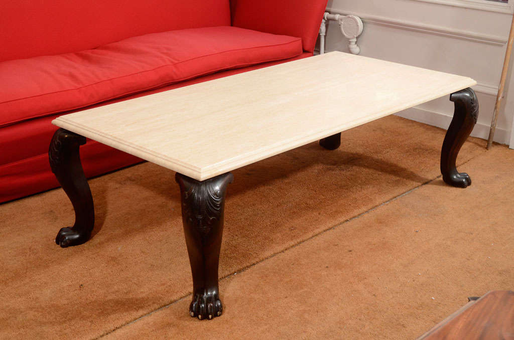 The travertine top with molded edges raised on four rosewood cabriole form legs with acanthus carving on the knees and ending in paw feet with ivory toenails.