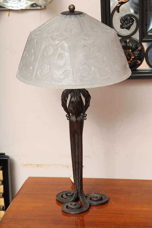 A French Art Deco table lamp, wrought iron base by Edgar Brandt, with Daum Freres acid etched glass shade.