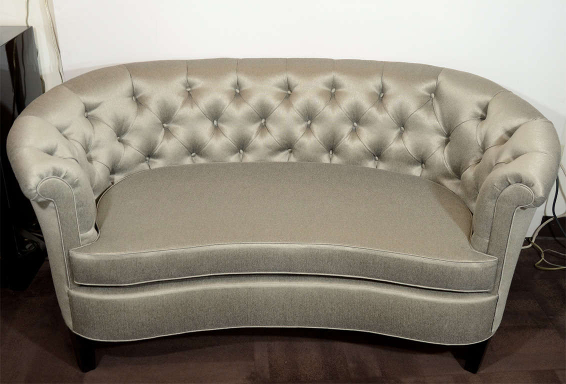 This sofa features a scrolled arm design with crescent seat and ebonized walnut legs,upholstered in mettallic sharkskin upholstery.