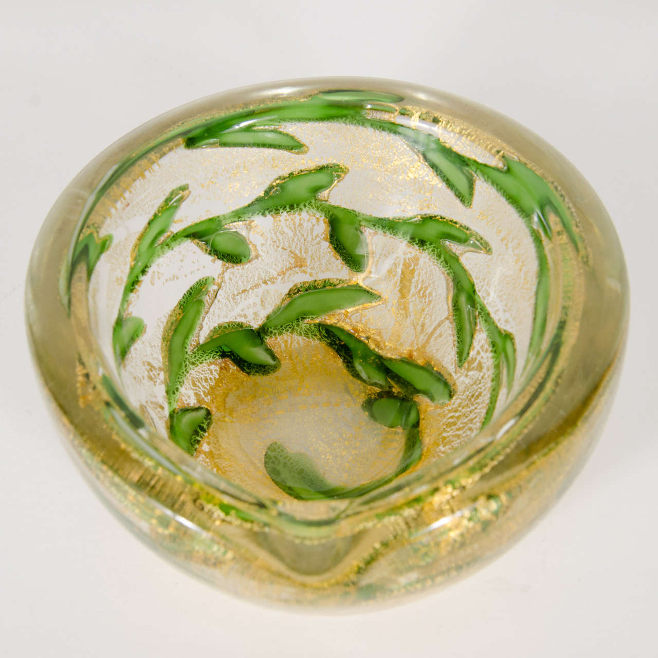 Mid-Century Modernist hand-blown Murano glass ashtray with 24K gold flecks and emerald green leafing motif.  This particular ashtray / bowl is comprised of thick hand-blown Murano glass that features a clean outer shell then is decorated on the