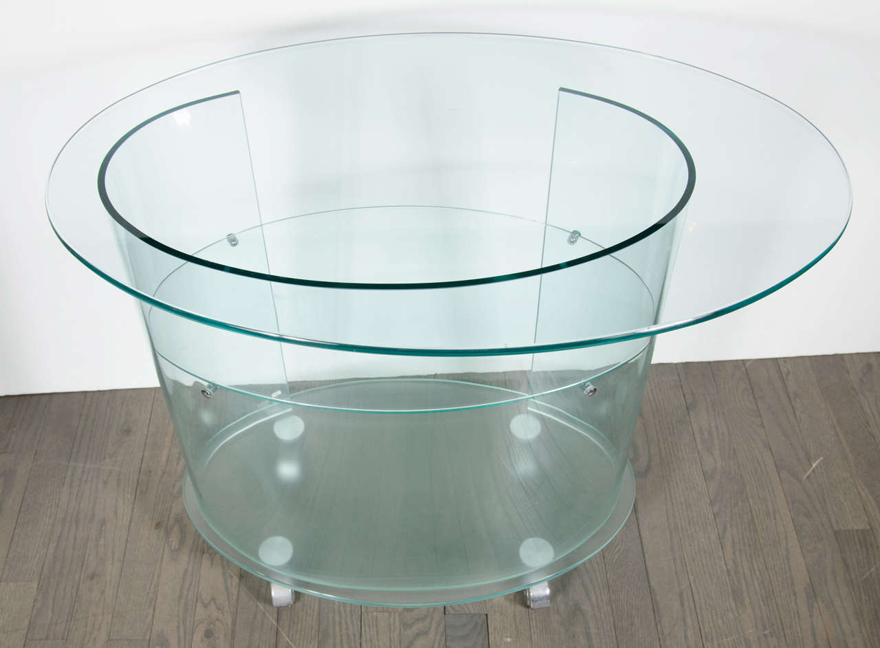 This Mid-Century Modernist three tier curved glass bar cart is beautiful in it's cylincdrical shape and design. With it's circular lines, and moveable wheels it would add a splash of fun to any living room geared towards entertaining and serving