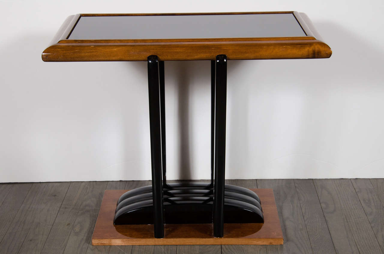 This exceptional Art Deco Machine Age occasional table features a streamlined design in walnut and black lacquer. It has strong geometric qualities, three bands stretch out across the base in black lacquer contrasting nicely with the warm tones of