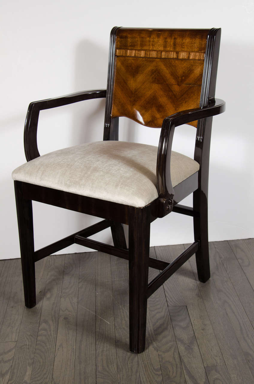 This exceptional Art Deco streamlined design arm desk chair is a rare entity. Designed with exotic bookmatched walnut and ebonized detailing, this chair is quintessential for any desk or office. It is in excellent condition. It has details of inlaid