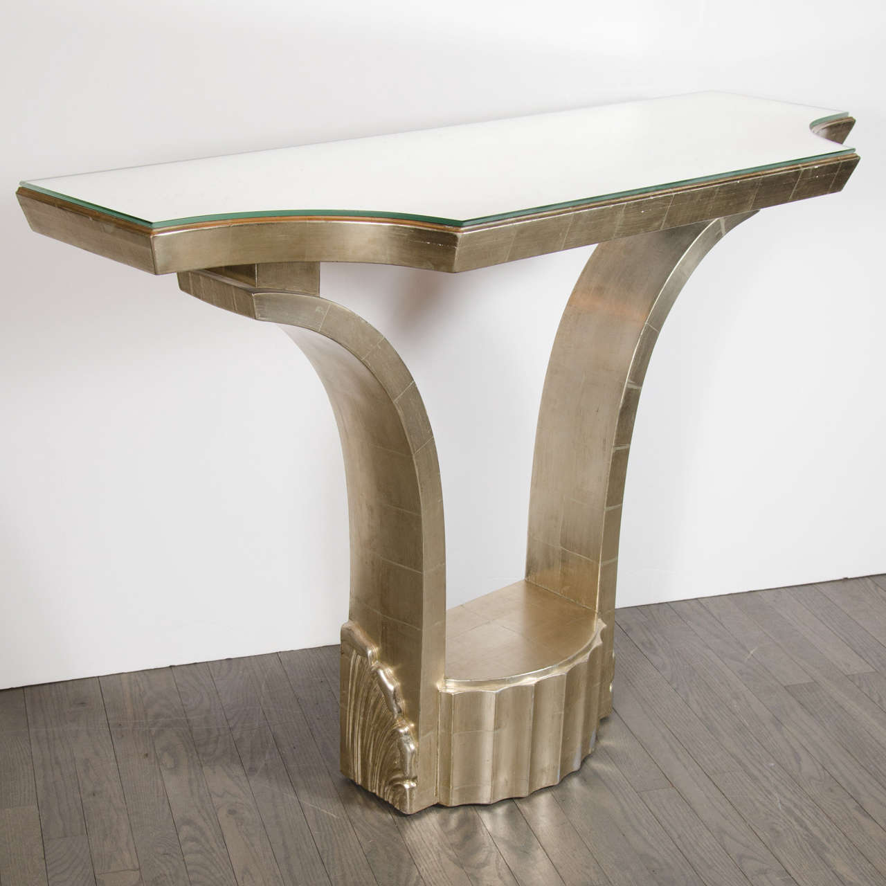 This jaw dropping console is a one of a kind piece. From the 1940's Hollywood Regency period, it has been designed with 24 karat white gold leafing, and  antiqued beveled mirror top showcasing it's stunning details and craftsmanship. It is in