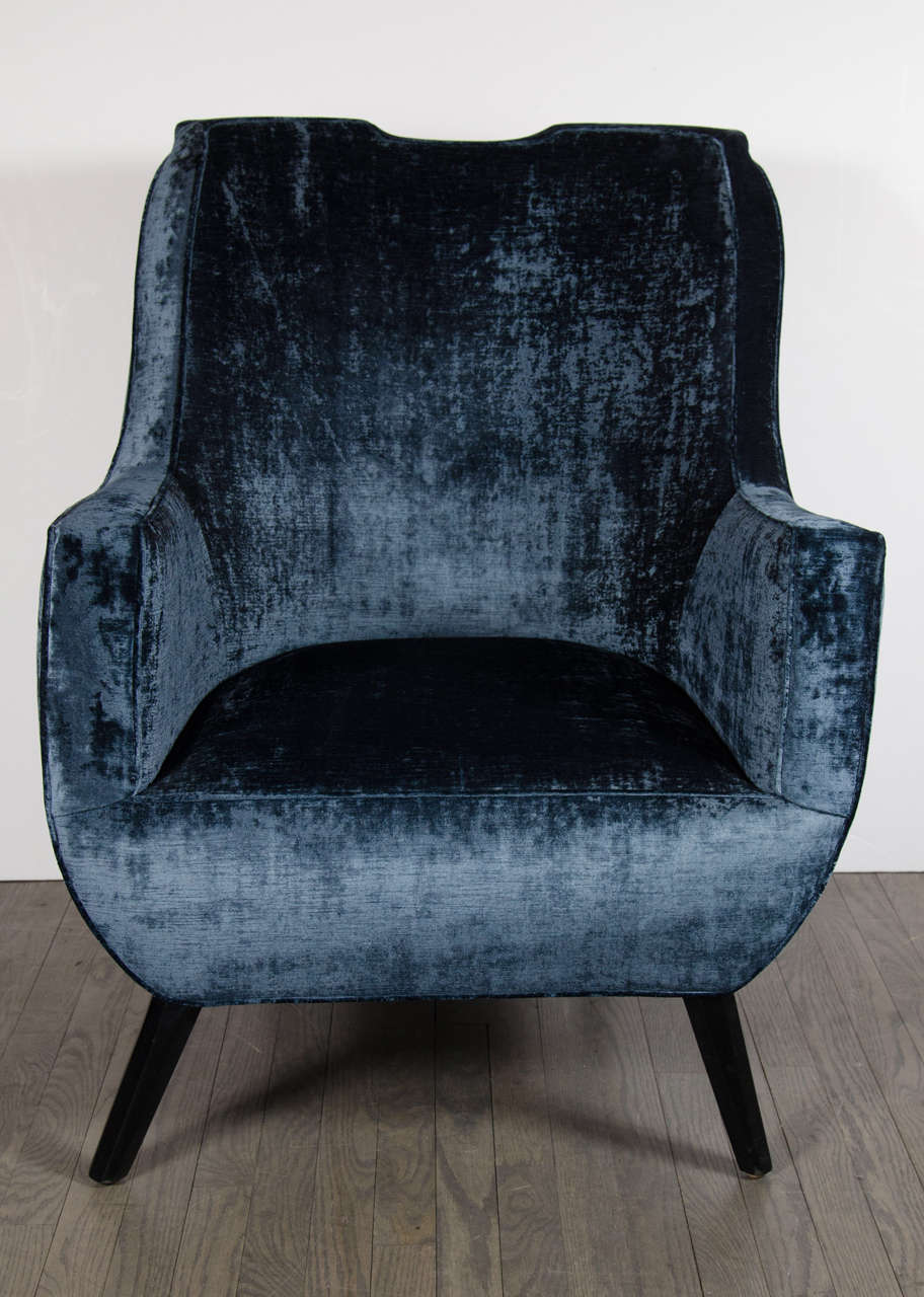 This stunning pair of Mid-Century Modernist Arm / Club Chairs are ultra chic. Upholstered in sapphire velvet upholstery, with a splayed leg design and ebonized walnut finish, the look and feel is luxurious. This pair would look beautiful in any 