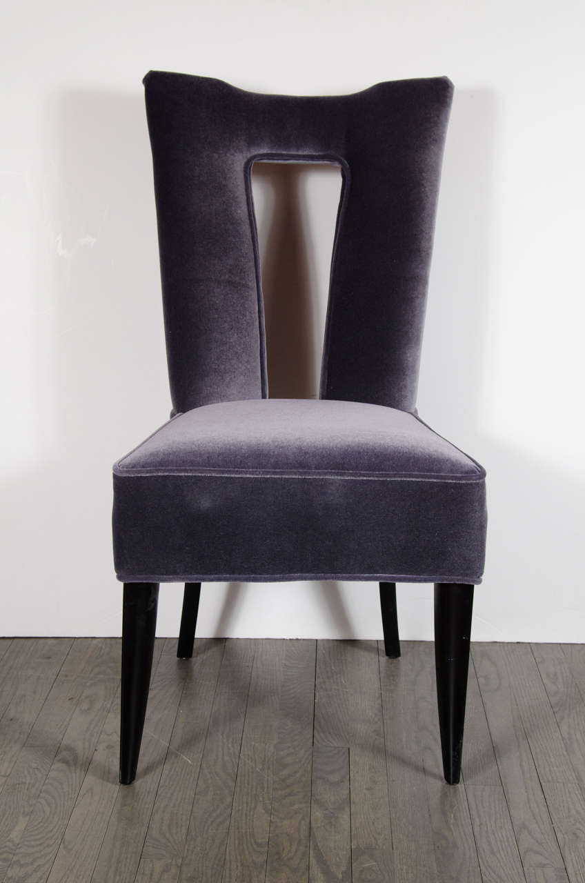 This gorgeous pair of Mid-Century Modernist cut-out back occasional chairs by Paul Laszlo are so chic. These chairs are newly upholstered in decadent amethyst mohair with ebonized walnut finishings and tapered legs. They are in mint condition.