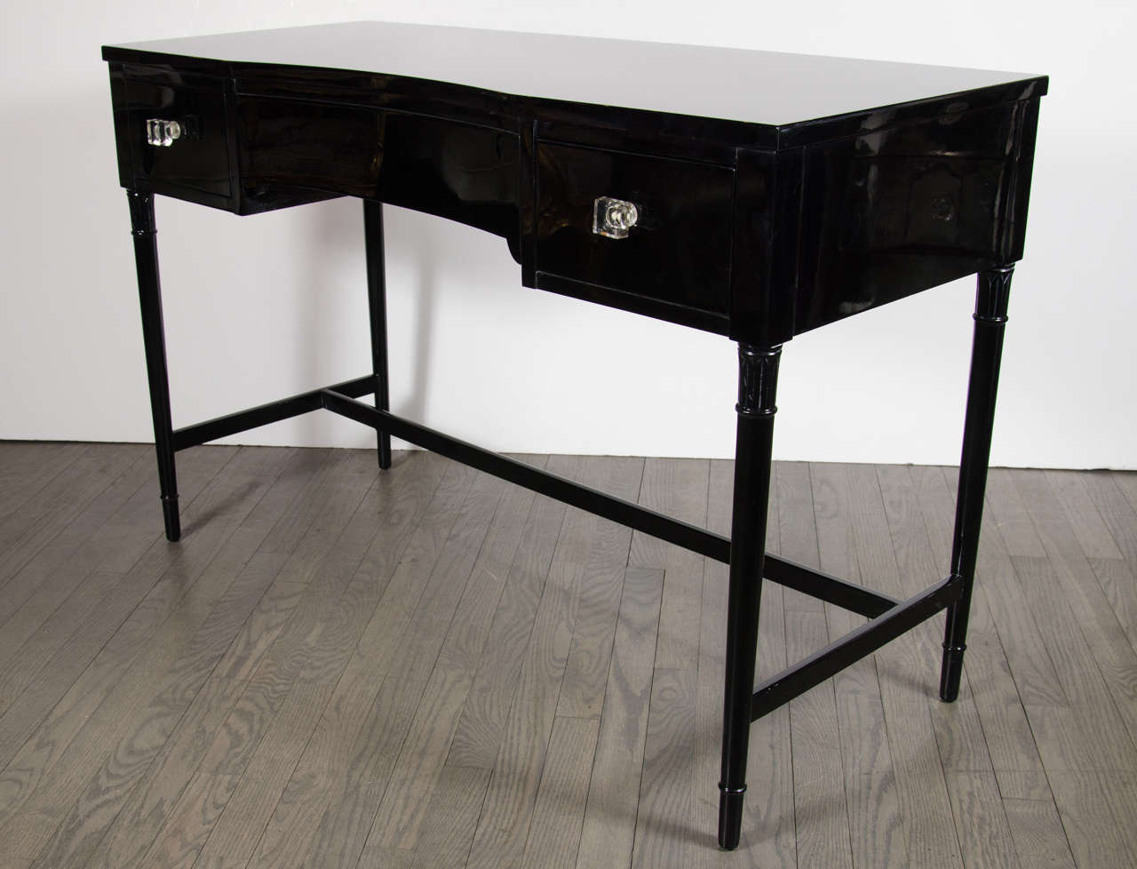 This beautiful 1940s Art Deco three-drawer desk / vanity was realized by the illustrious American maker Grosfeld House- where legendary designers such as Lorin Jackson and Vladimir Kagan- refined their practice. It features an ebonized walnut body