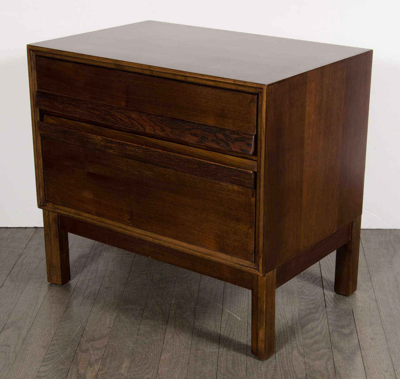 This gorgeous pair of Mid-Century Modernist night stands / end tables are perfect for any bedroom or living room. These are finished in hand rubbed walnut and can add a classic modern look to any room. This pair is in excellent condition.