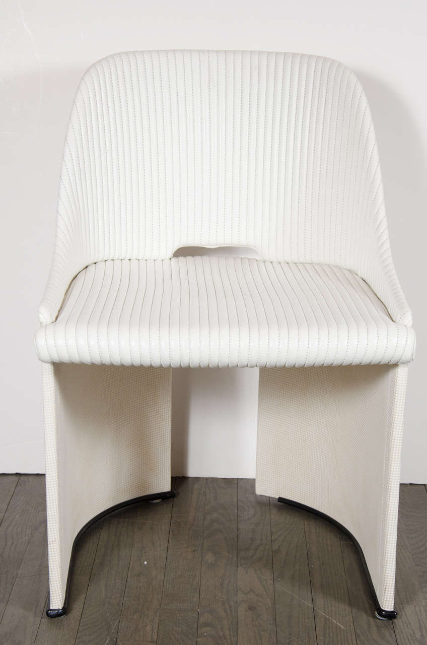 This ultra chic Mid-Century Modernist occasional chair features clean modern lines, the back and legs are one piece which mould around the form of the seat leaving a cut-out design at the back. It has a lineal stitched leather design in egg-shell