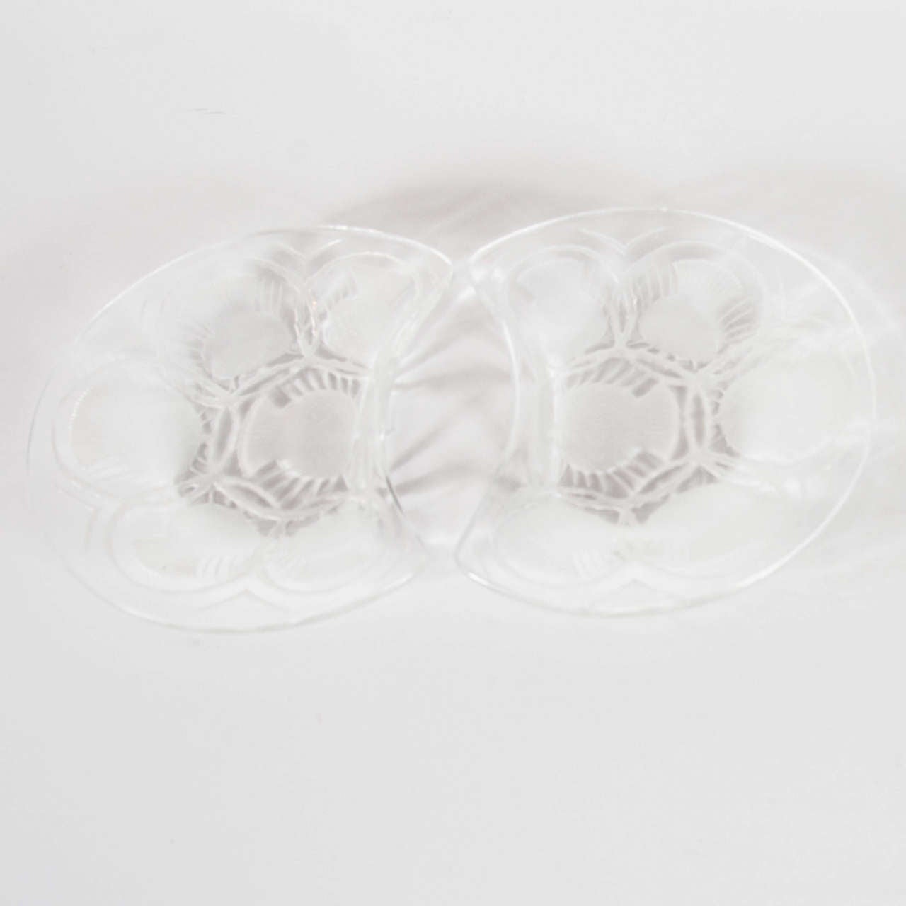 This pair of stunning Lalique plates bear a reverse etched stylized Art Deco pineapple motif with geometric detailing . It bears the Lalique signature on the bottom of each.