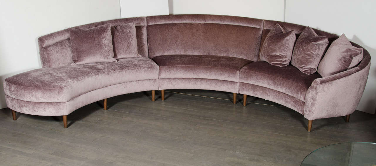 This ultra chic sofa is made of three pieces that are attached. They have been newly upholstered in a luxe amethyst velvet. The conical legs are made of a hand rubbed walnut. This sofa has been mint restored and reupholstered.