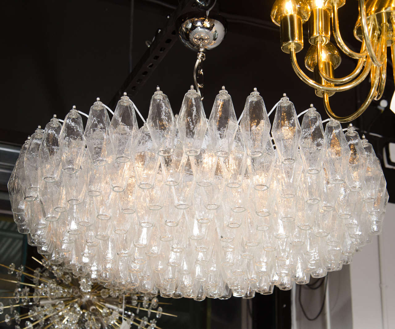 This effervescent Murano glass chandelier by Venini features numerous handblown Murano glass polyhedral shades. Each glass polyhedral shade is individually hung from its frame by hand. The frame features the slightest upward graduation from its