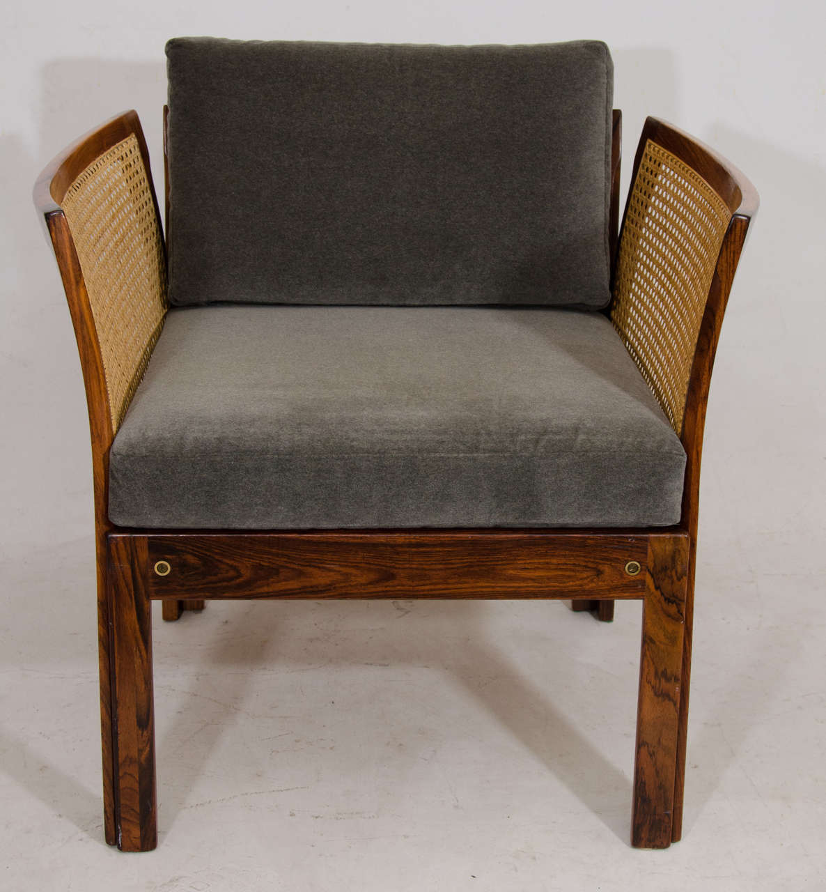 Beautiful pair of Danish chairs distinguished by gracefully curved side panels of caning framed in solid rosewood. This pair has cotton/mohair fabric cushions. Please contact for location.