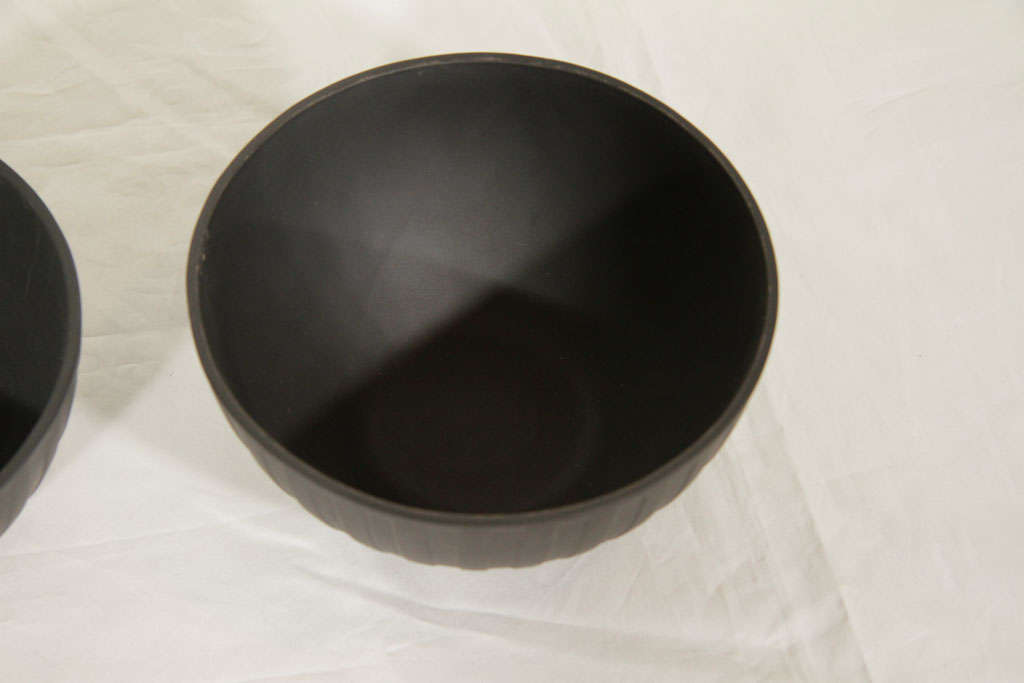 A pair of Wedgwood Black Basalt engine turned bowls with a neoclassical design of ribbing from top to bottom. Black Basalt was created by Josiah Wedgwood in the 18th century. Wedgwood transformed Egyptian Black, a traditional Staffordshire