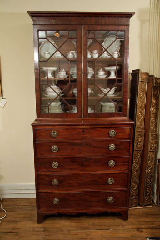 English, George III mahogany secretary bookcase in two parts, glazed doors and,

Shelved interior. Lower part with two false drawers opening to a maple veneered.

Fitted interior, above three long graduated drawers, shaped apron and bracket feet.