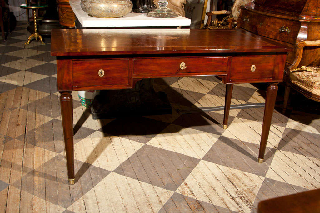 TURNED LEGS WITH BRASS CAPS, 3 DRAWERS  AND FAUX  DRAWERS ON BACK, GOLD TOOLED  DARK BROWN LEATHER TOP
