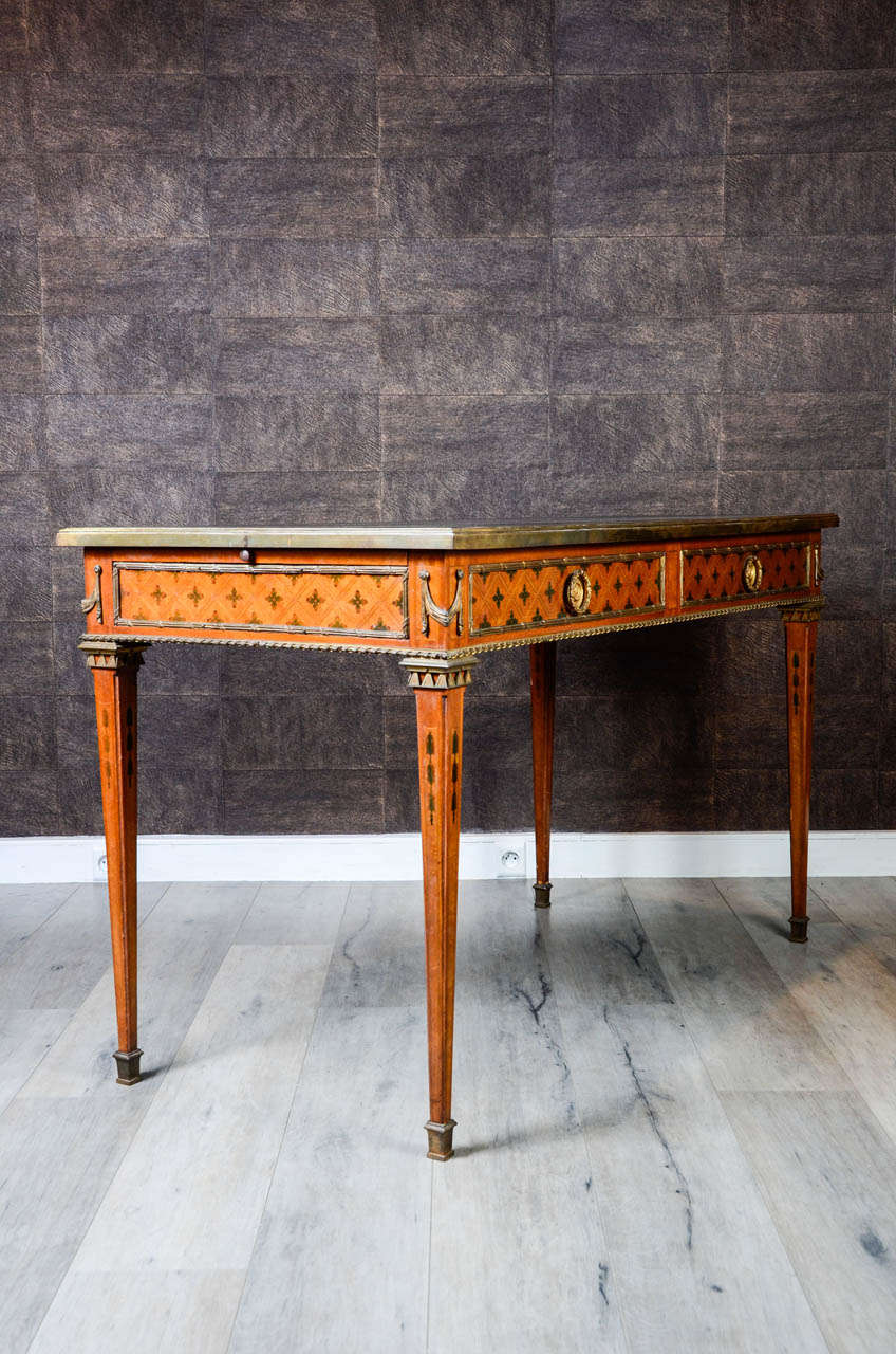 French bureau plat , Top inset with a gilt-tooled black coloured leather writing surface whith neo-classical ormolu mounts; having a leather fitted pullout on both sides.  Tulipwood and mahogany   false drawers to the reverse.