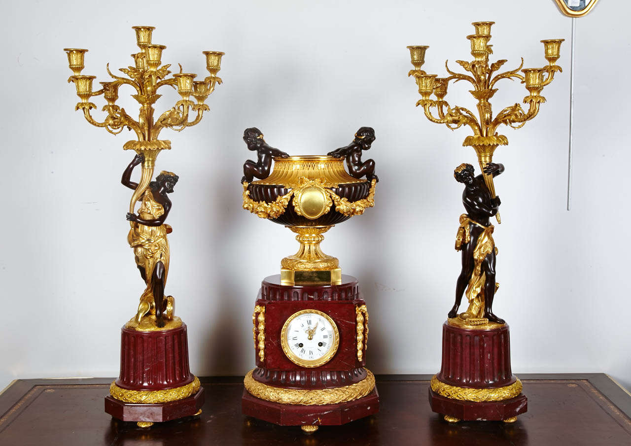 red griotte marble and bronze mantel clock and 2 candelabras
exceptional set of rare 3 pieces.
clock holding a bronze double patina bronze with putti handles
candelabras with nympheas holding 9 arms of lights
double patina bronze
to complete