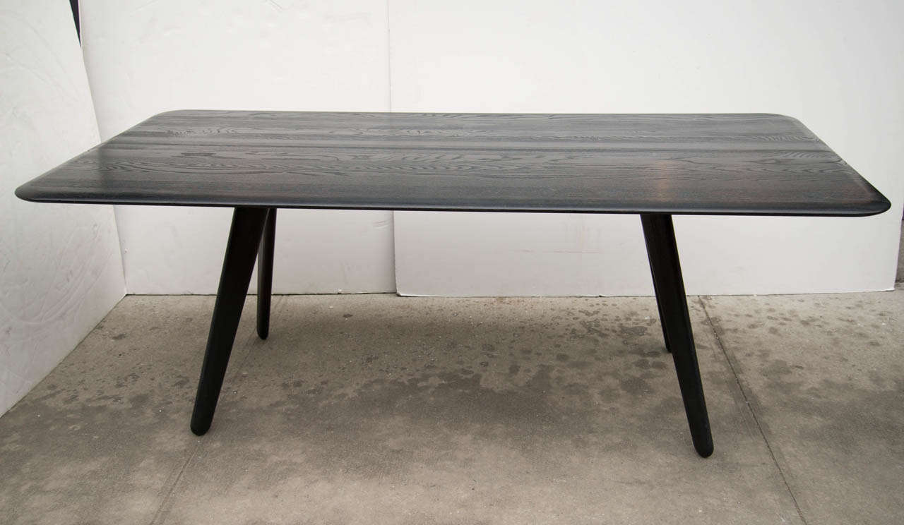 Contemporary solid oak wood slab dining table in a cerused black lacquered finish.  The table has a rectangular form with rounded edges and features sculptural 