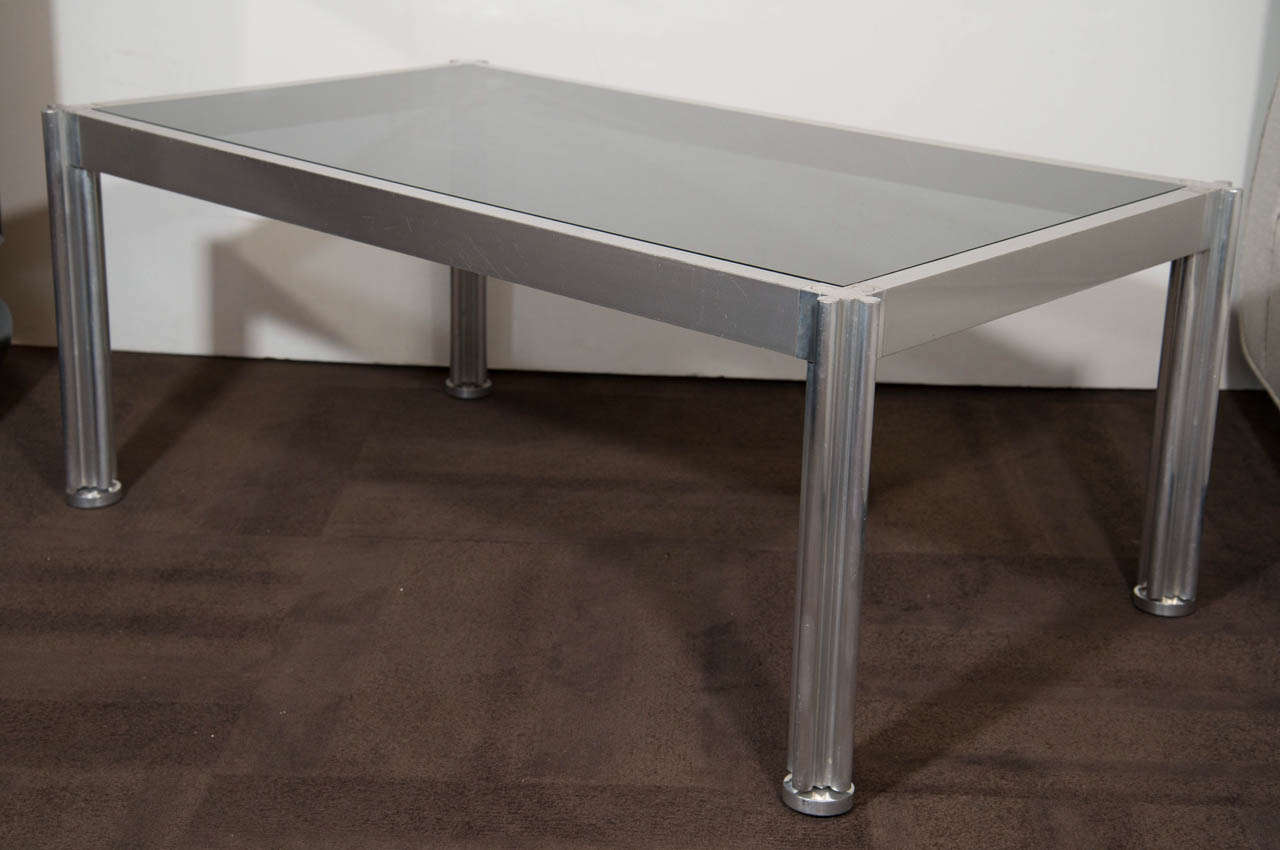 Art Deco coffee table with chrome and aluminum frame with fluted leg design with stylized puzzle piece top detail. Fitted with a smoked glass inset top.