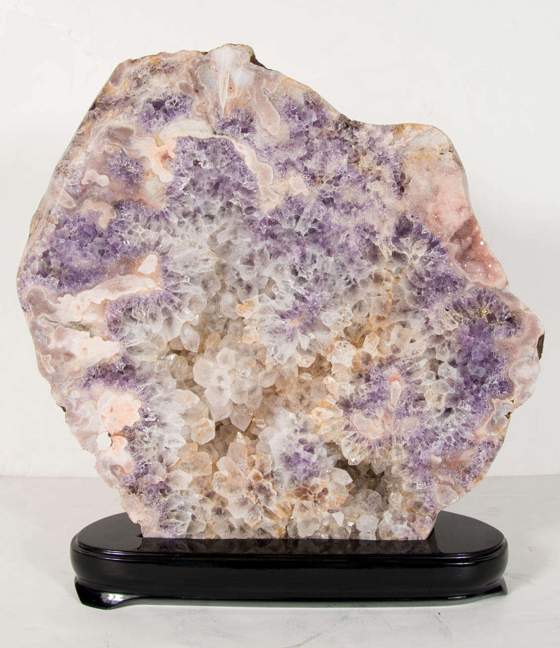 Spectacular sliced geode mineral specimen of Quartz that frames an exquisite array of organic crystalized spokes that form beautiful vignettes of Quartz & Amethyst crystals that are set inside a creamy white surrounding. Mounted on an ebonized