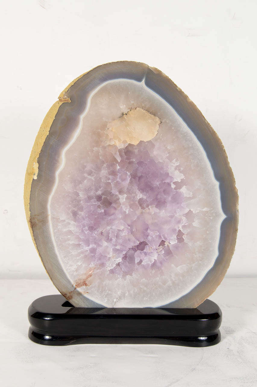 This luxe and outstanding sliced geode mineral specimen has an epicenter of rich Amethyst Crystal which is surrounded by a smokey Quartz trim that leads into a exquisite array of tone on tone mixes of milky whites, creams, pale blues and grays.  It