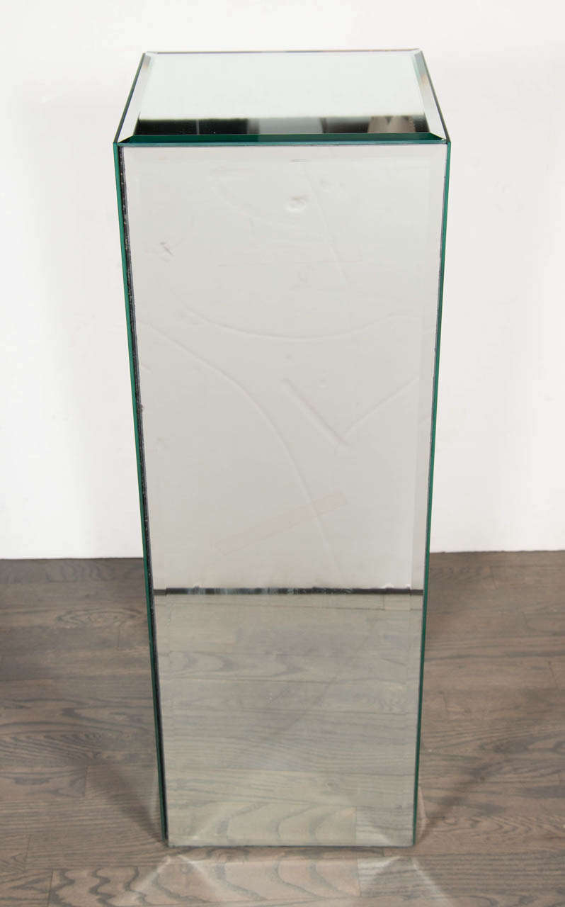 This Mid-Century Modernist pedestal is mirrored on all four sides including the top. Each panel is hand beveled and is perfect for displaying sculptures or objects.