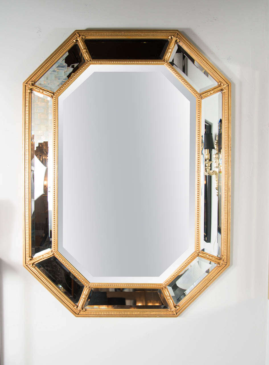 This Mid-Century Modern octagonal mirror with gilt beaded frame & Fleur de lys detailing. It has a segmented border with inset hand beveled mirror and the main mirror is also beveled. Can be hung horizontally or vertically.