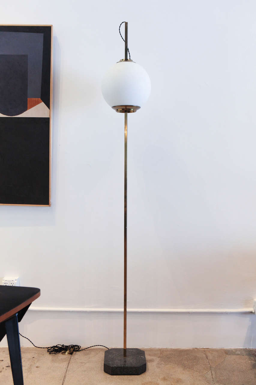 Dominion's signature glass globe floor lamp with brass stand and marble base.