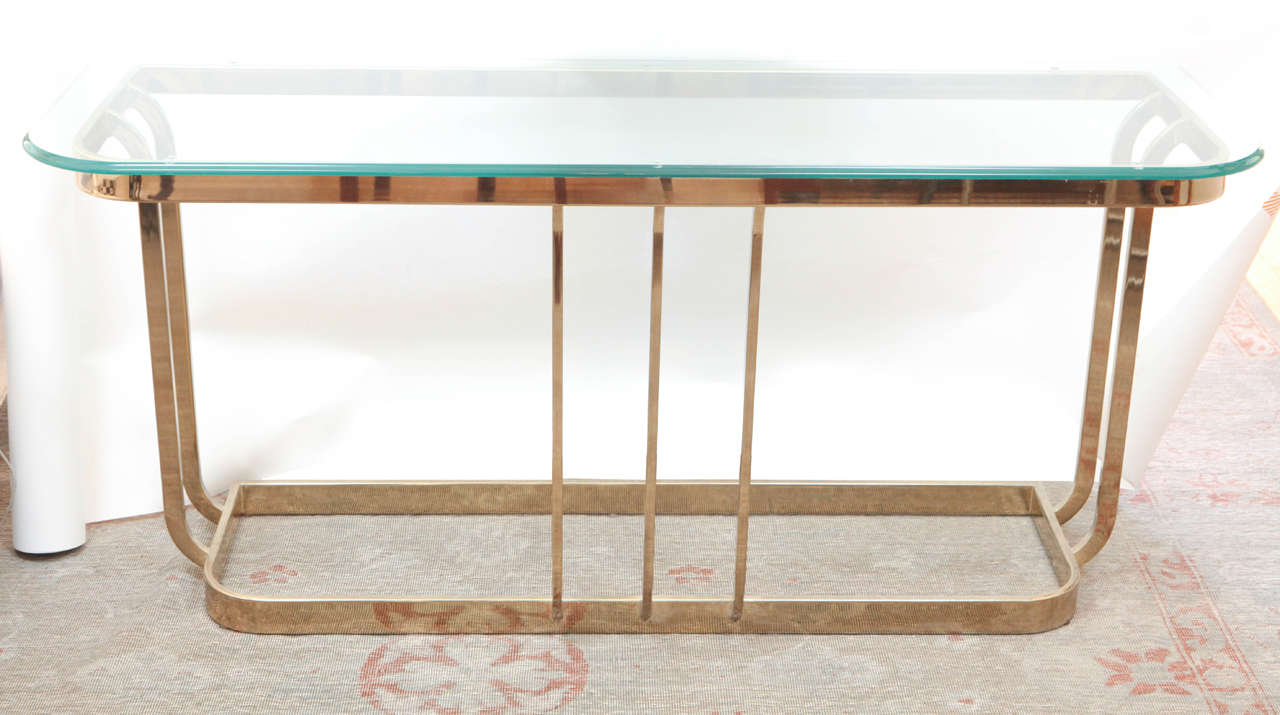 Mid-Century Modern Baugman table with glass top and polished brass.