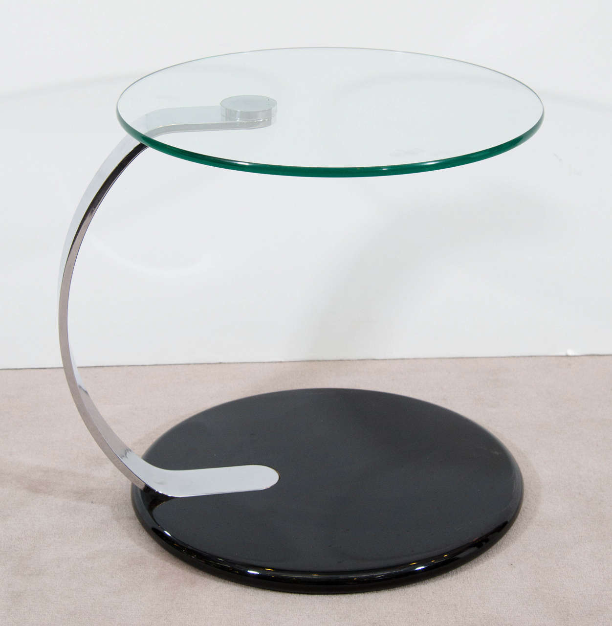 A vintage pair of circular glass and chrome side or end tables with a black acrylic base. Can also be used as nightstands. Good condition with age appropriate wear.