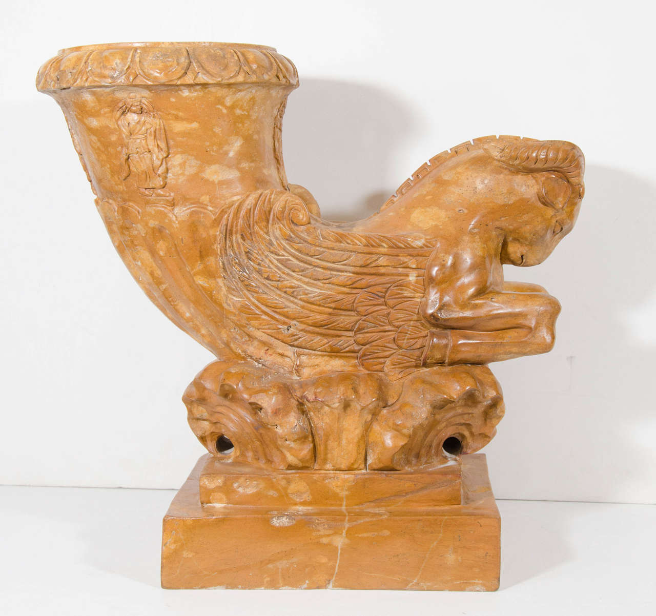 A 20th century pair of neoclassical style Siena marble urns depicting a winged ram. Good condition with some cracks and wear to marble due to age.