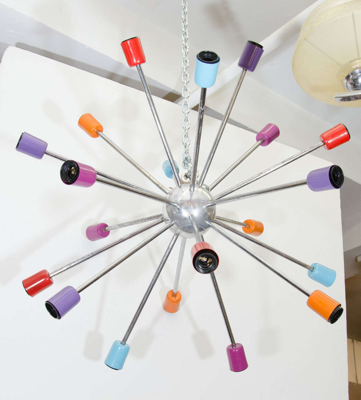 A vintage chrome Sputnik chandelier with multi-colored sockets in blue, purple, red, and orange.  European sockets and wiring.  Vintage condition with a fair amount of rust.