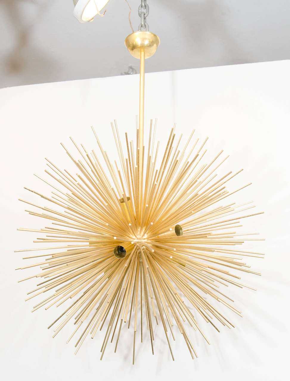 A vintage Sputnik chandelier with multi brass rays emanating out of a brass sphere. European sockets and wiring. Good vintage condition with age appropriate patina.