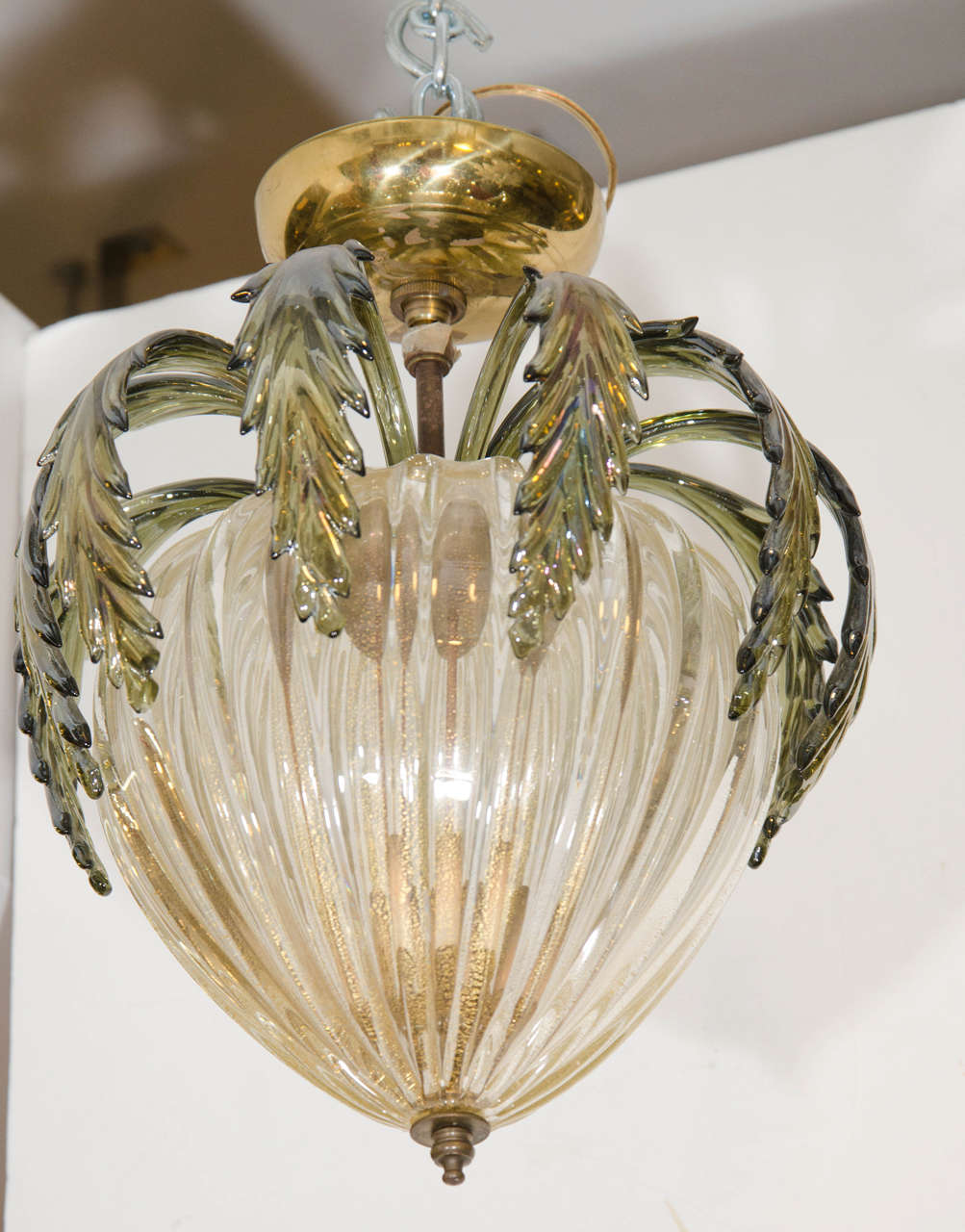 A vintage Barovier & Toso Murano glass gold flecked and ribbed pendant or chandelier with green iridescent leaves around the top, and brass plated canopy. This pendant takes three candelabra bulbs.