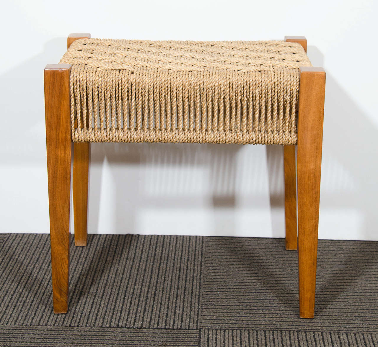 A vintage walnut bench or stool with woven seat in rope. Good vintage condition with age appropriate wear.