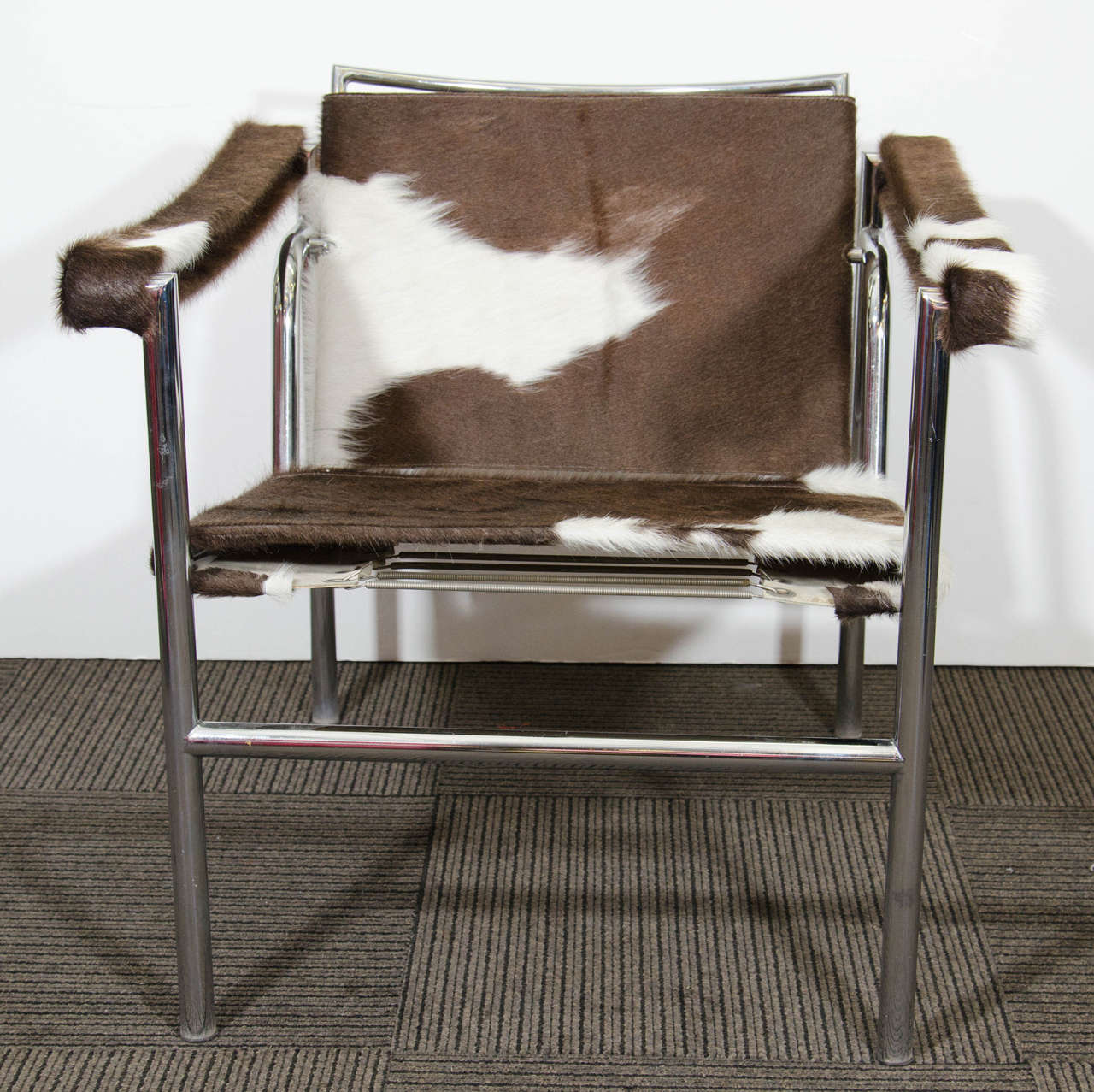 A vintage LC1 sling chair newly reupholstered in cowhide with adjustable back and a tubular chrome frame. The piece was designed by Le Corbusier and manufactured by Stendig.