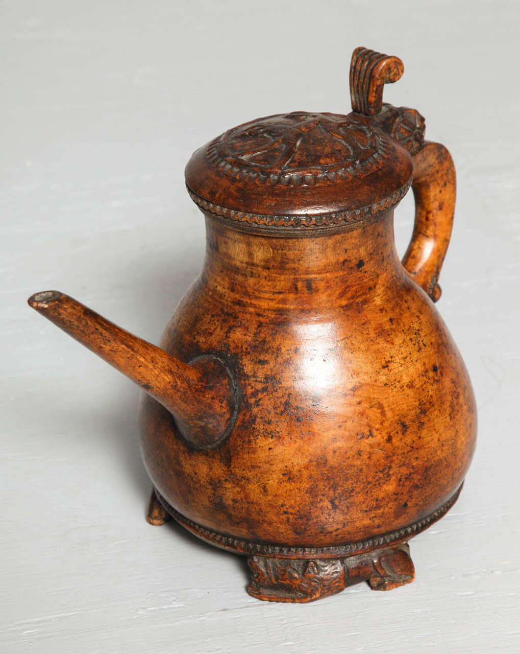 Most unusual late 18th century Norwegian Folk Art burl birch pitcher of a form more typically found as a peg tankard, the lid with relief carved lion, over a swelled body with elongated spout, standing on three lion carved feet, the whole with rich