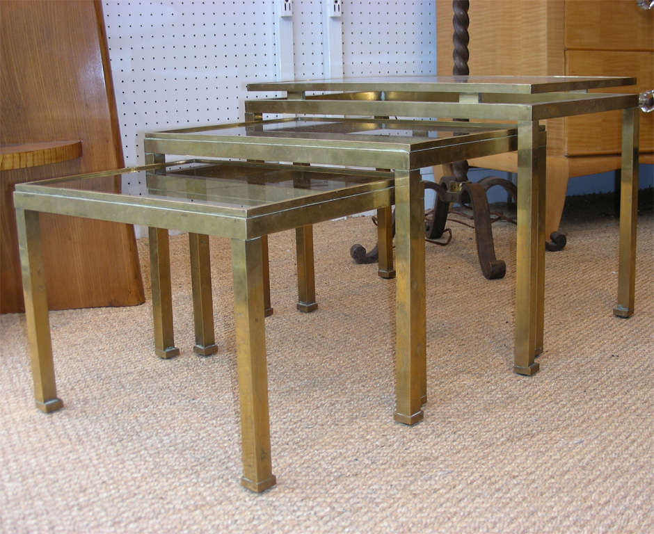 Three 1970s stacking tables by Maison Jansen, in gilt brass with smoked glass top. Middle table height 32 cm., length 44 cm., depth 32 cm. Smallest table: 28, 38, 29.