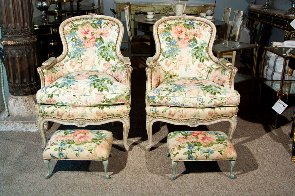 Pair of French Louis XVI style bergère chairs, circa 1950s, the crème-peinte frame with floral fabric upholstery, cushioned seat, on cabriole legs. By Maison Jansen. Ottomans are sold.
Provenance: Christie's New York Interior Sale, from the estate