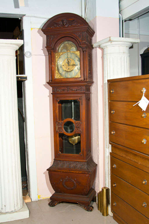 A fine turn of the century Grandfather Clock. Wonderful oak carved case adorning an angel bonnet top supported by a heavily carved case. The interior works signed the front displaying a Tiffany and Company Tag.
