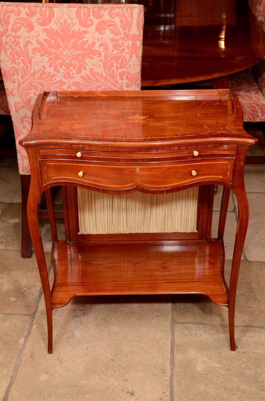 A George III (Hepplewhite) mahogany and satinwood foliate marquetry ladies serpentine cheval writing or work table in the manner of Ince and Mayhew. The top Inlaid with satinwood urn and foliate scrolls and with boxwood and kingwood banding, the